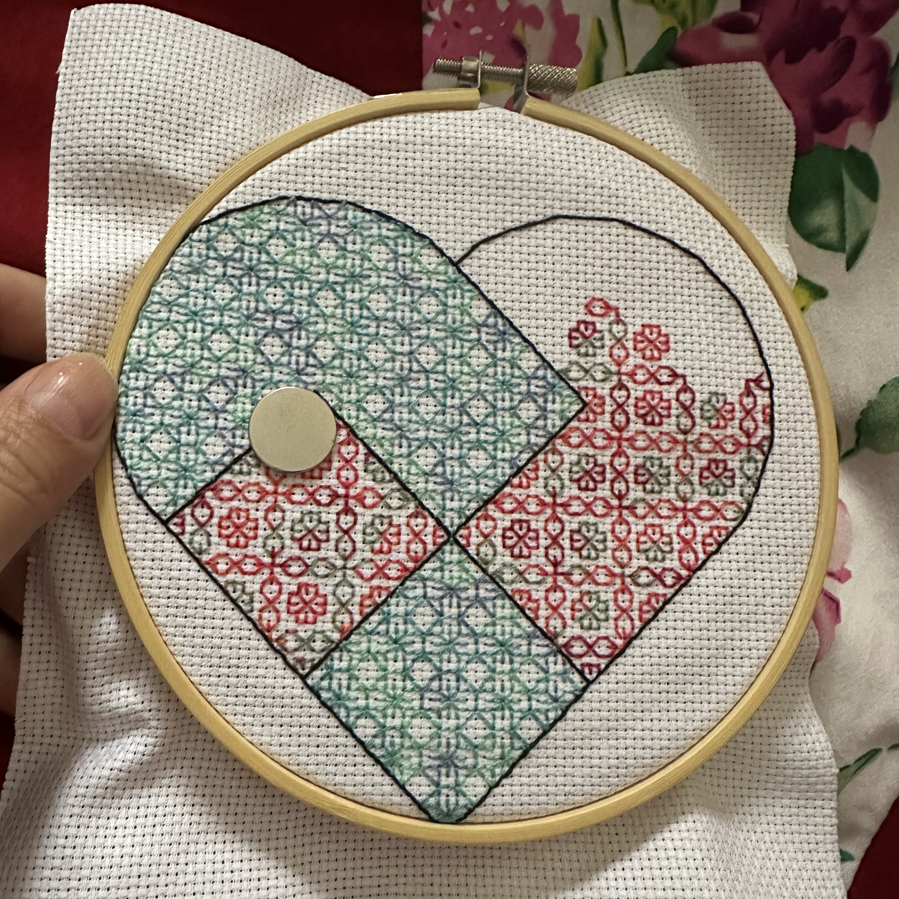 Broderie en blackwork d'un cœur danois, avec deux fils dégradés, l'un bleu et vert, l'autre rouge et gris.