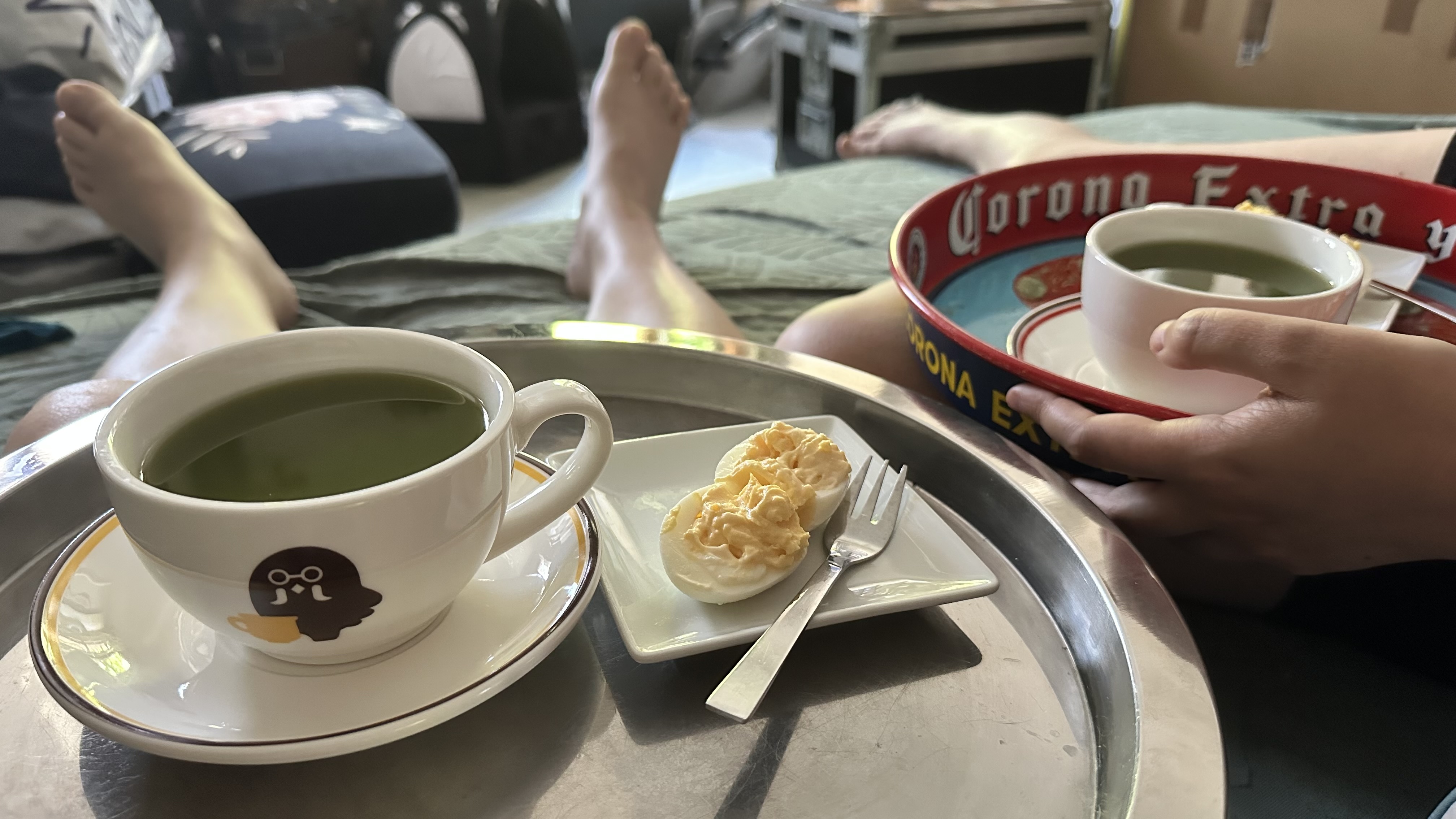 Nos deux plateaux de petit-déjeuner : deux tasses de Brewster dans Animal Crossing, remplie de thé vert, et chacune une assiette avec deux moitié d'œufs mimosa