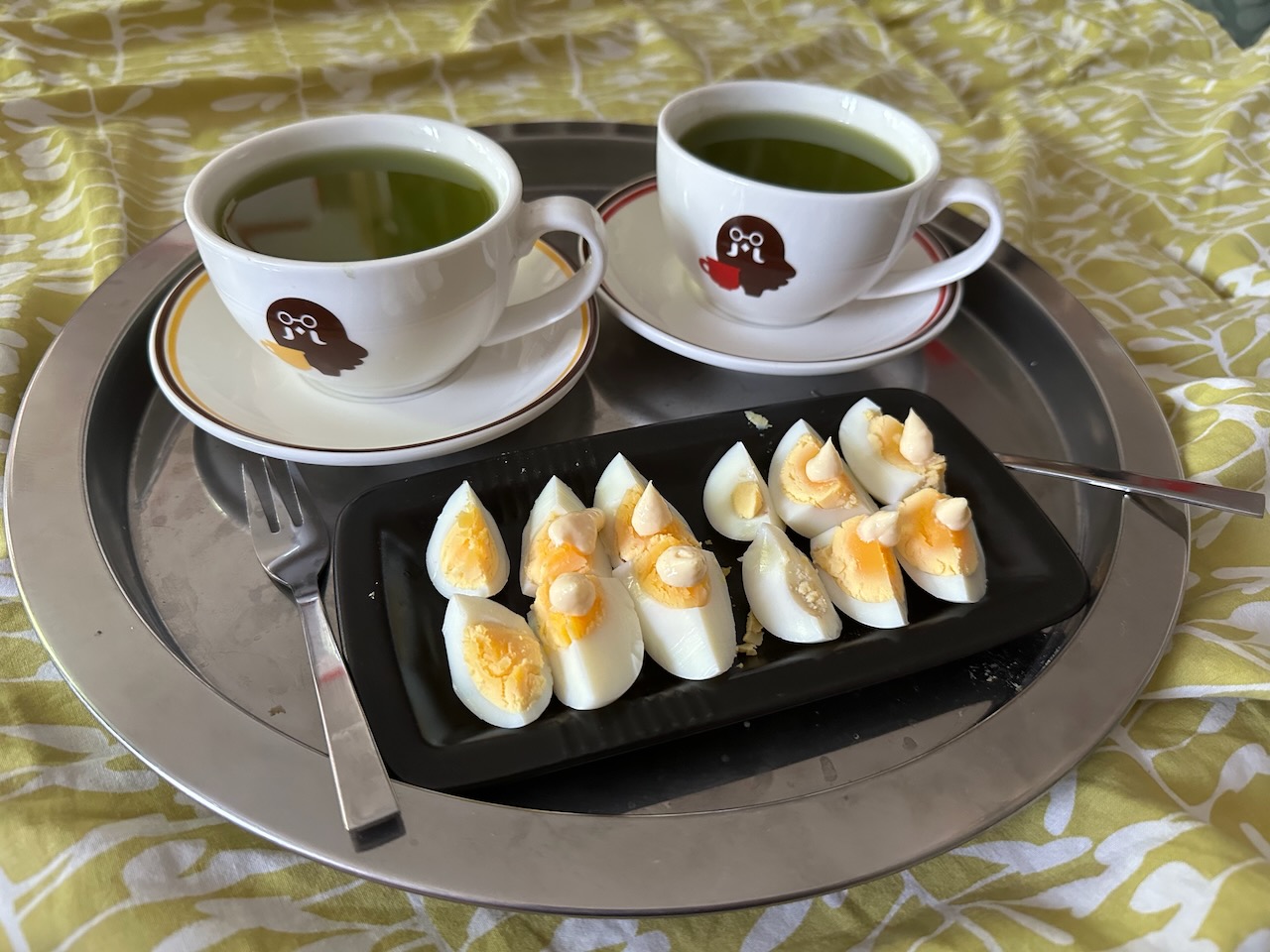 deux tasses Brewster pleines de thé vert au matcha, et deux œufs durs découpés en six petits morceaux