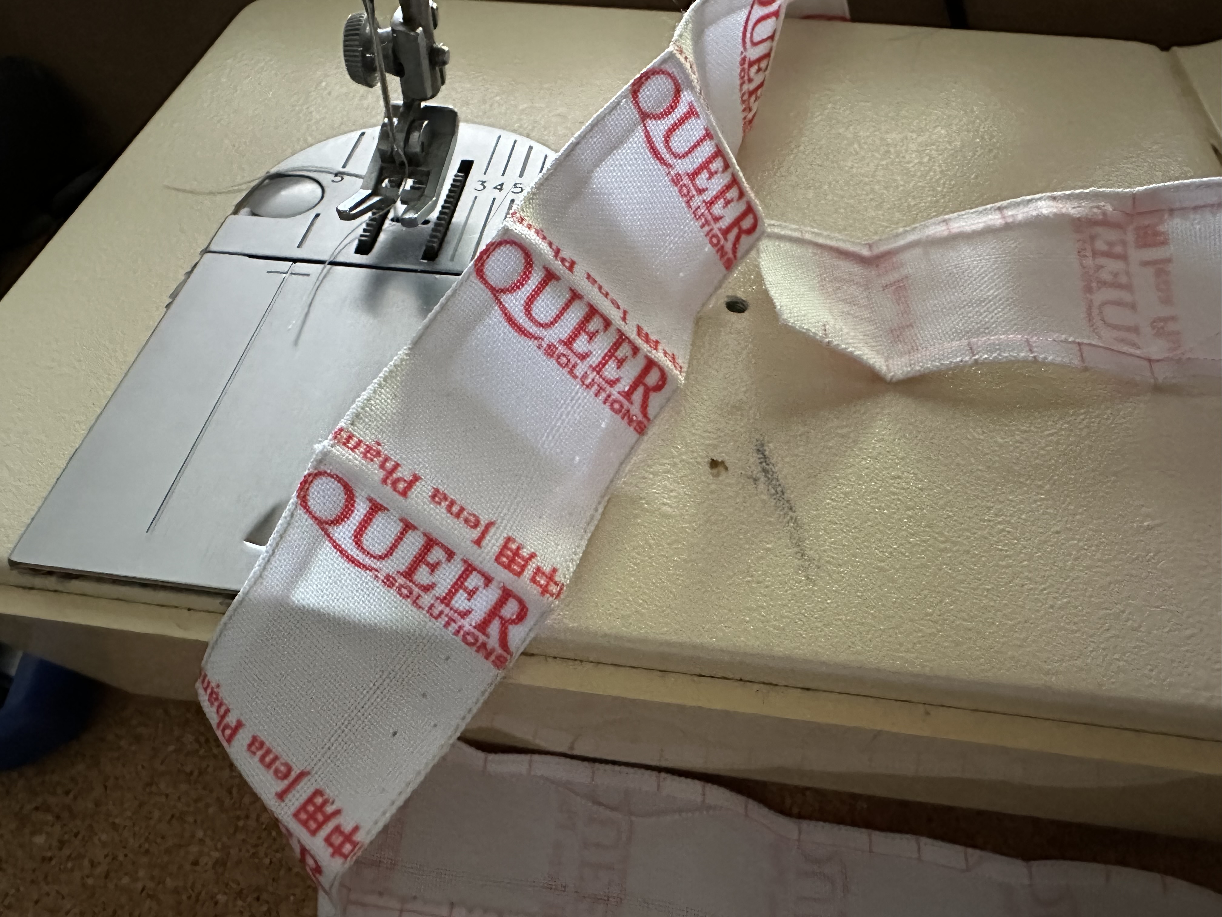 gros plan d'un ruban d'étiquettes marques queer.solutions et Jena Pham