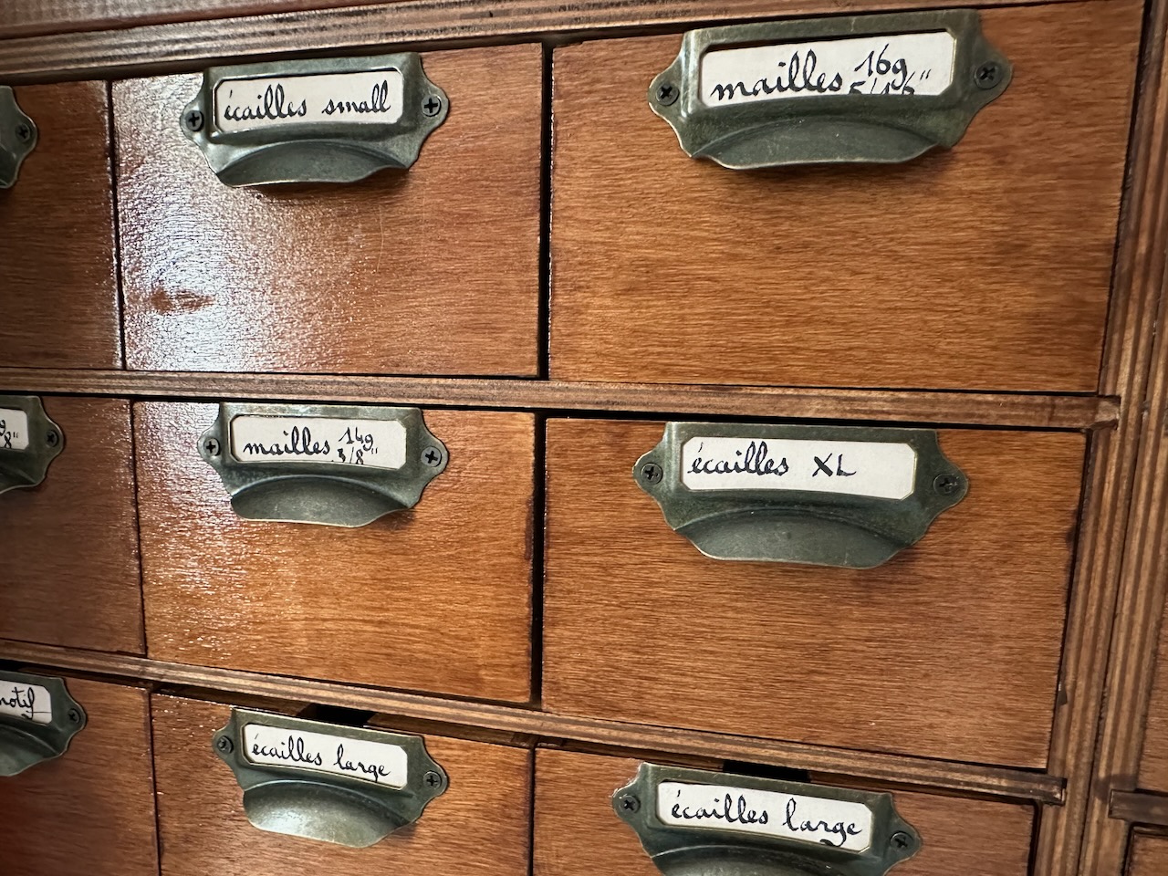 gros plan d'étiquettes calligraphiées sur un meuble en bois vernis