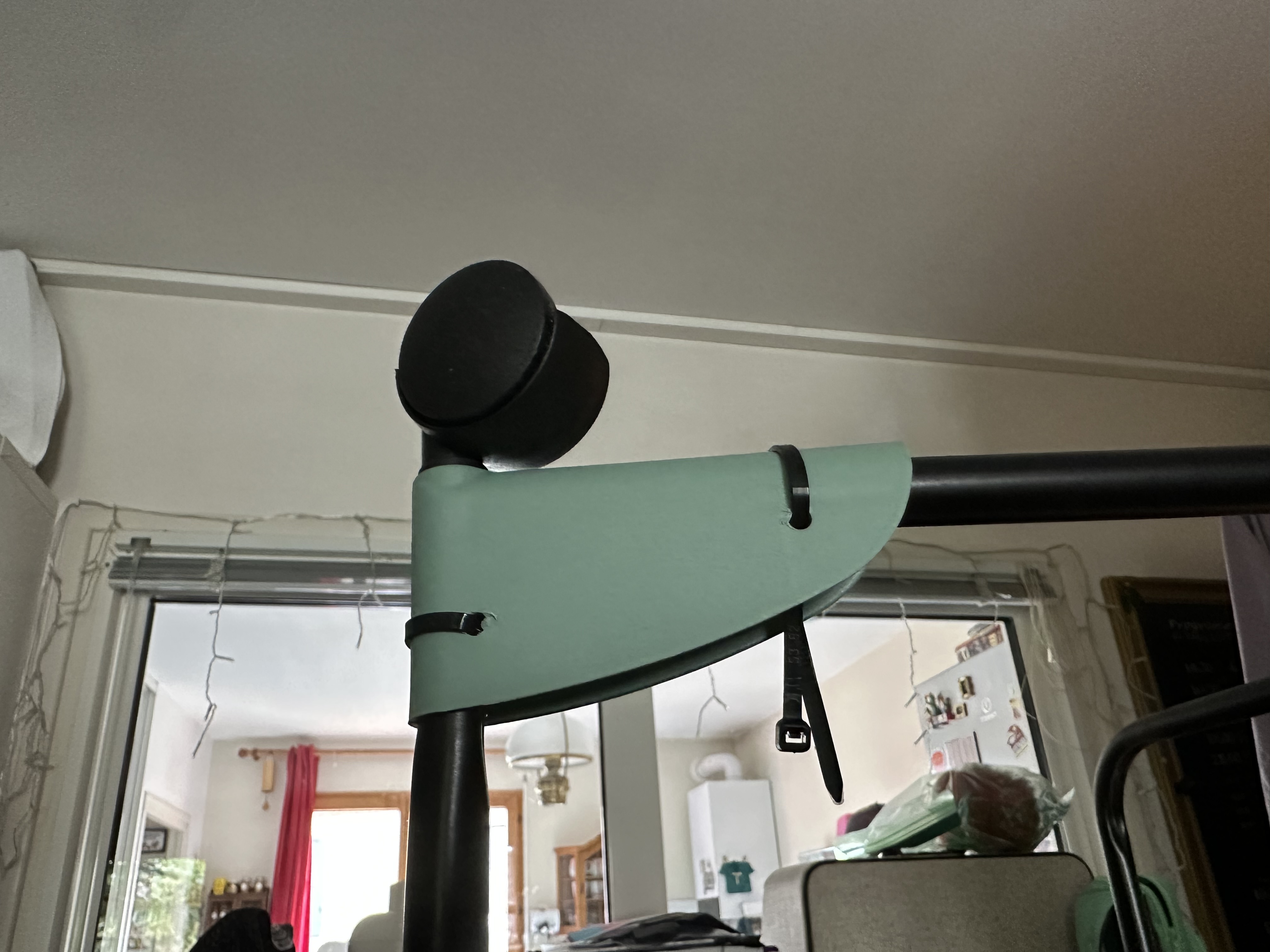 Gros plan d'un pied de l'étendoir, la tête en bas, avec un zip tie fermé, et l'autre en court de fermeture.